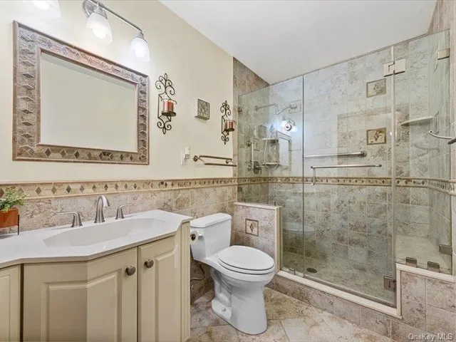 a bathroom with a toilet sink vanity and mirror