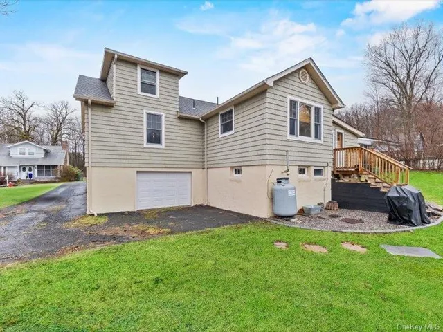 a view of a house with a yard and sitting area