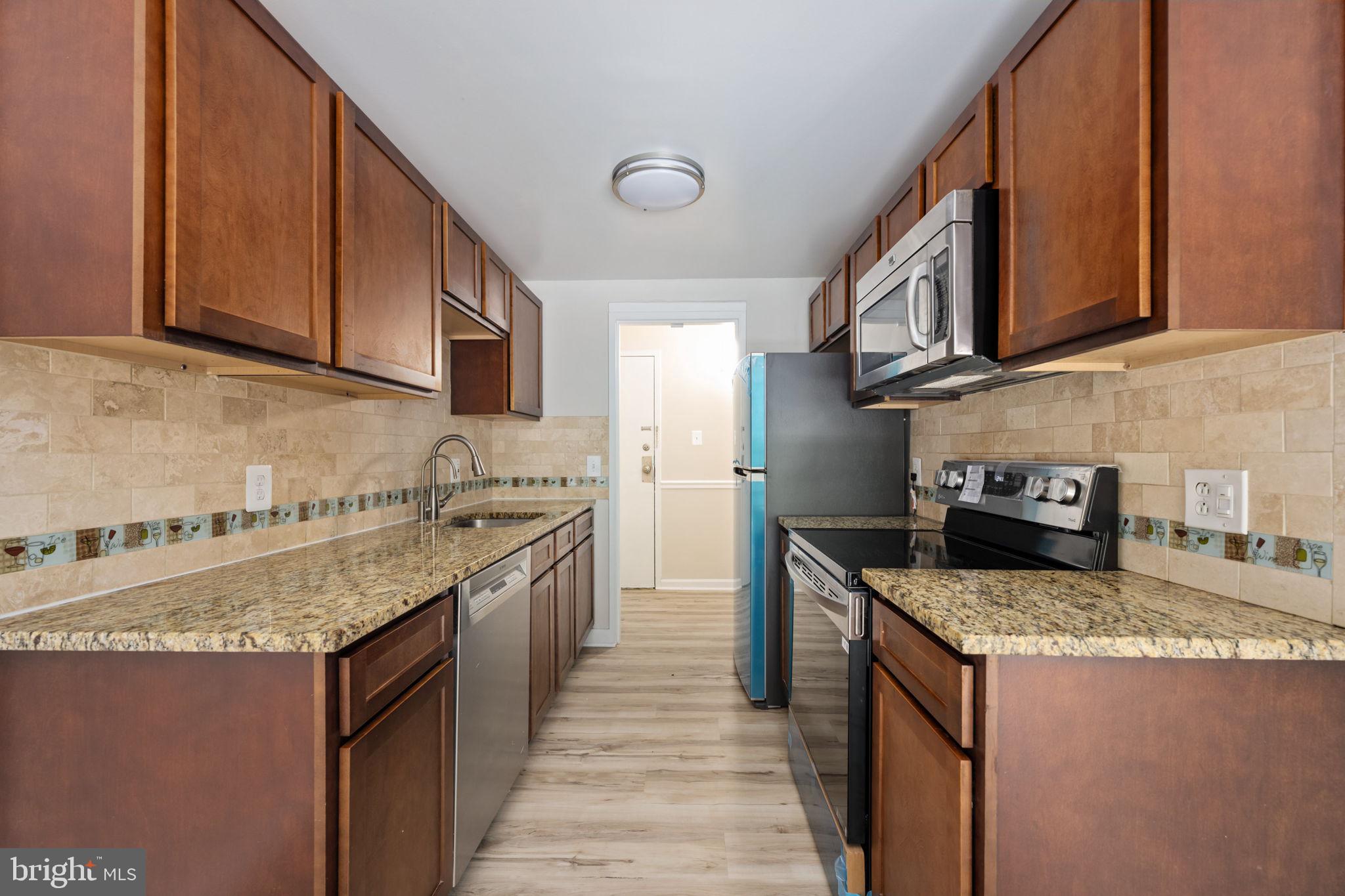 11659 Stoneview Square, Unit 11C Reston, VA 20191 - Photo 14 of 50 a kitchen with stainless steel appliances granite countertop a sink stove and refrigerator