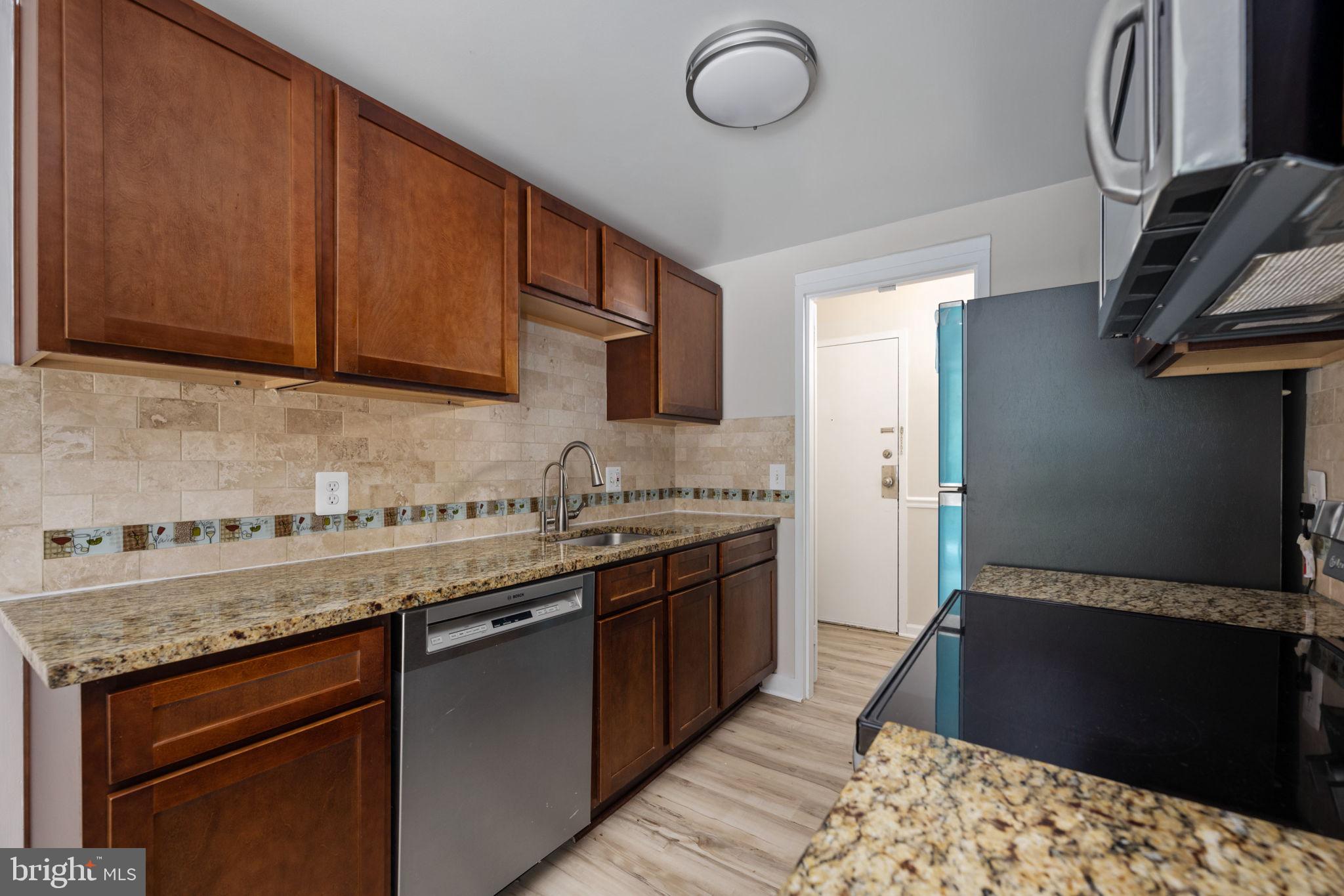 11659 Stoneview Square, Unit 11C Reston, VA 20191 - Photo 15 of 50 a kitchen with stainless steel appliances granite countertop a sink stove and cabinets