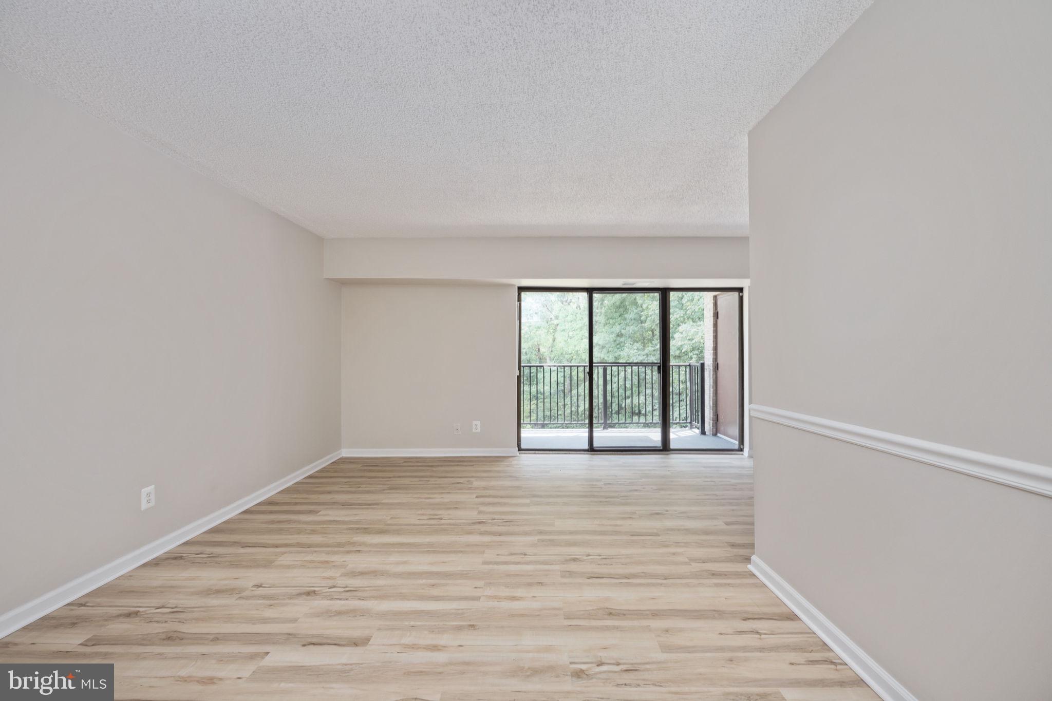 11659 Stoneview Square, Unit 11C Reston, VA 20191 - Photo 17 of 50 a view of an empty room with wooden floor and a window