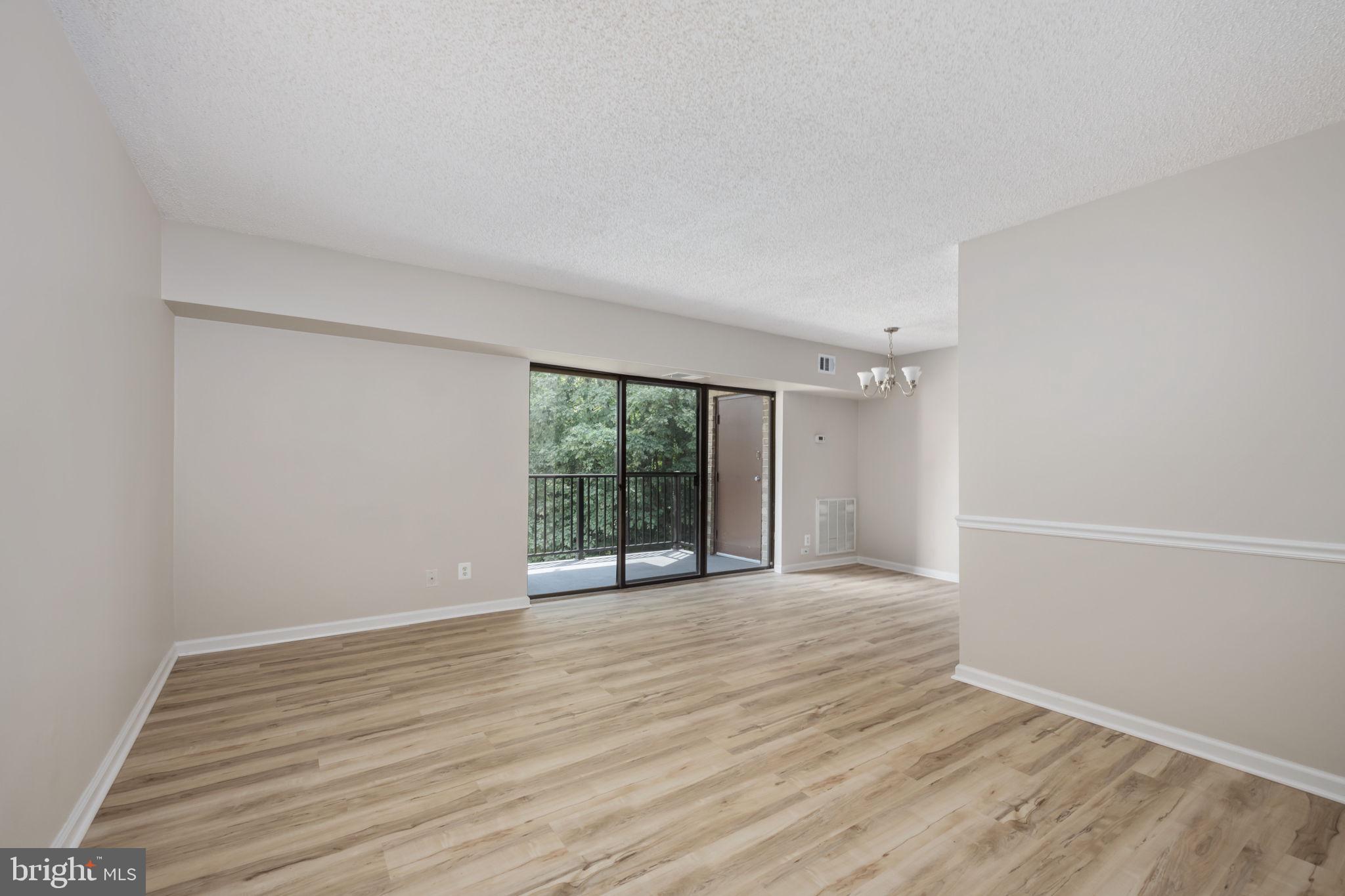 11659 Stoneview Square, Unit 11C Reston, VA 20191 - Photo 20 of 50 a view of an empty room with wooden floor and a window