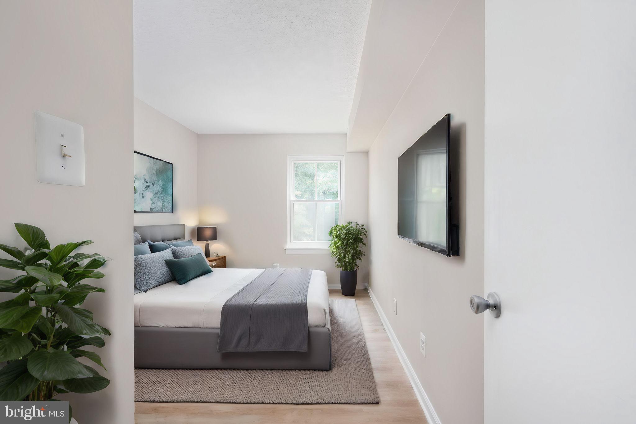 11659 Stoneview Square, Unit 11C Reston, VA 20191 - Photo 31 of 50 a bedroom with a large bed and a potted plant