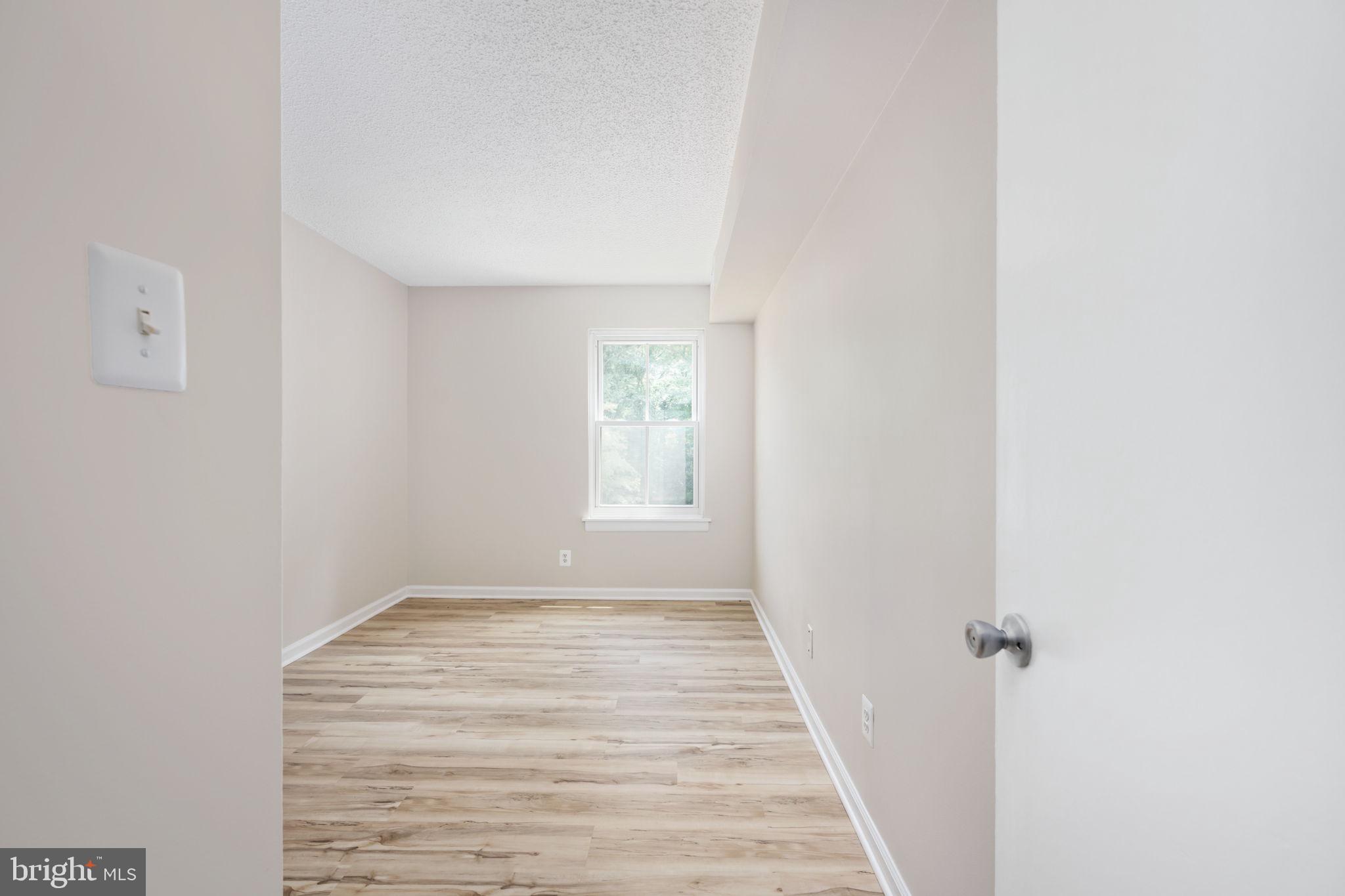 11659 Stoneview Square, Unit 11C Reston, VA 20191 - Photo 32 of 50 a view of a hallway with wooden floor