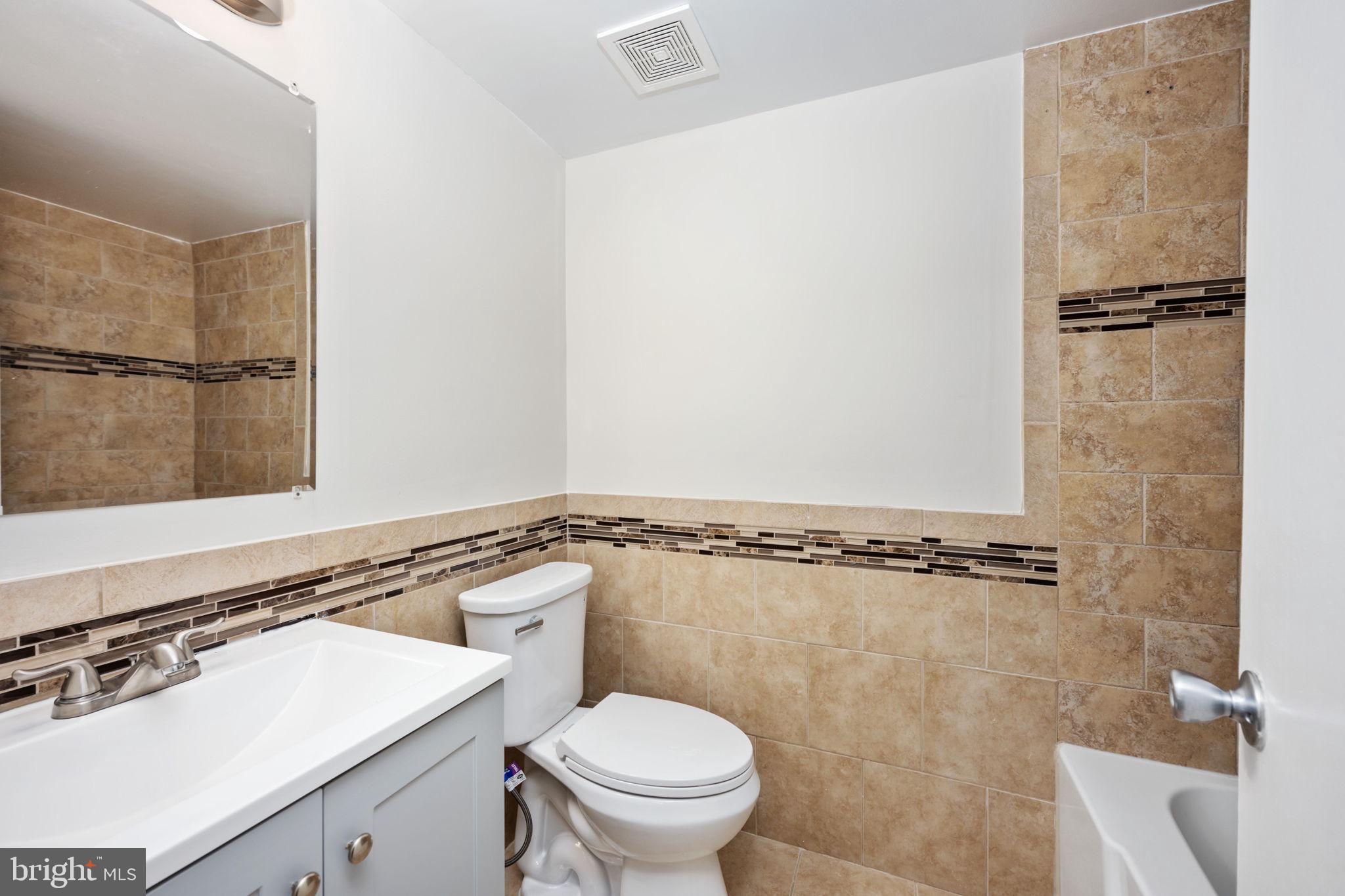 11659 Stoneview Square, Unit 11C Reston, VA 20191 - Photo 36 of 50 a bathroom with a sink a toilet a vanity and mirror
