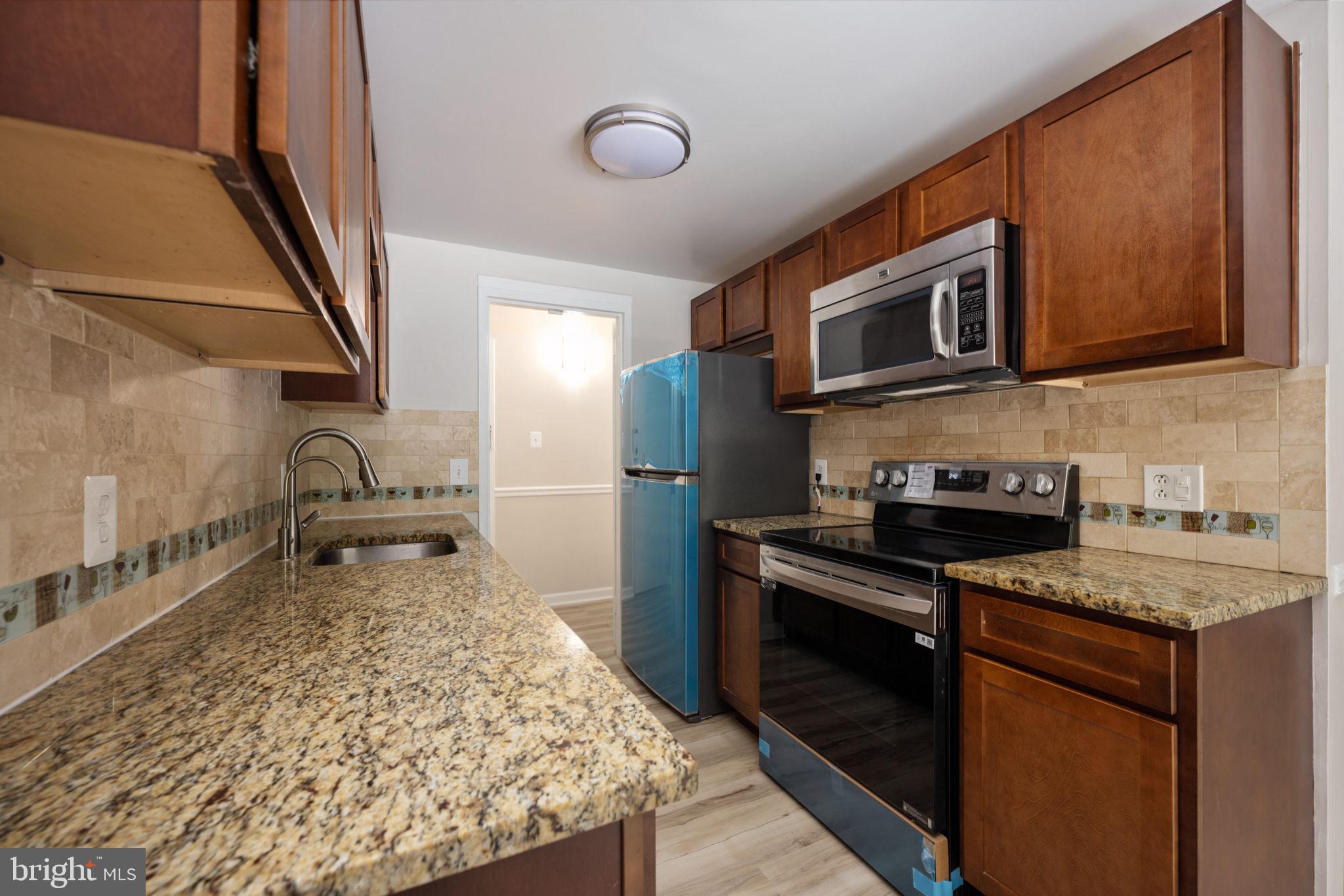 11659 Stoneview Square, Unit 11C Reston, VA 20191 - Photo 4 of 50 a kitchen with stainless steel appliances granite countertop a stove and a sink