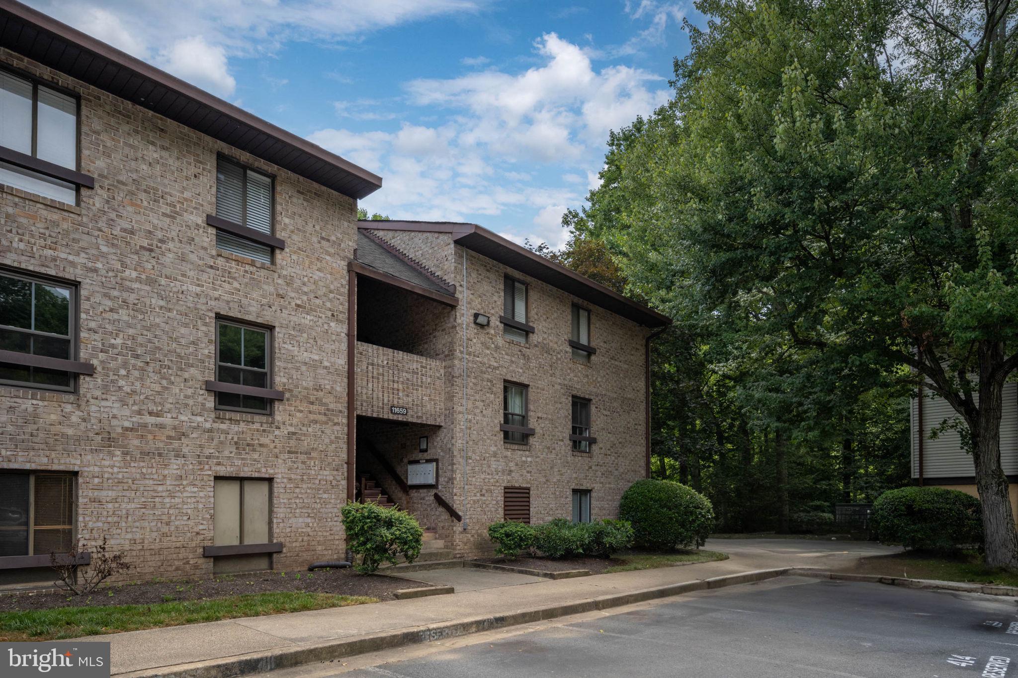 11659 Stoneview Square, Unit 11C Reston, VA 20191 - Photo 42 of 50 a front view of a house with a garden