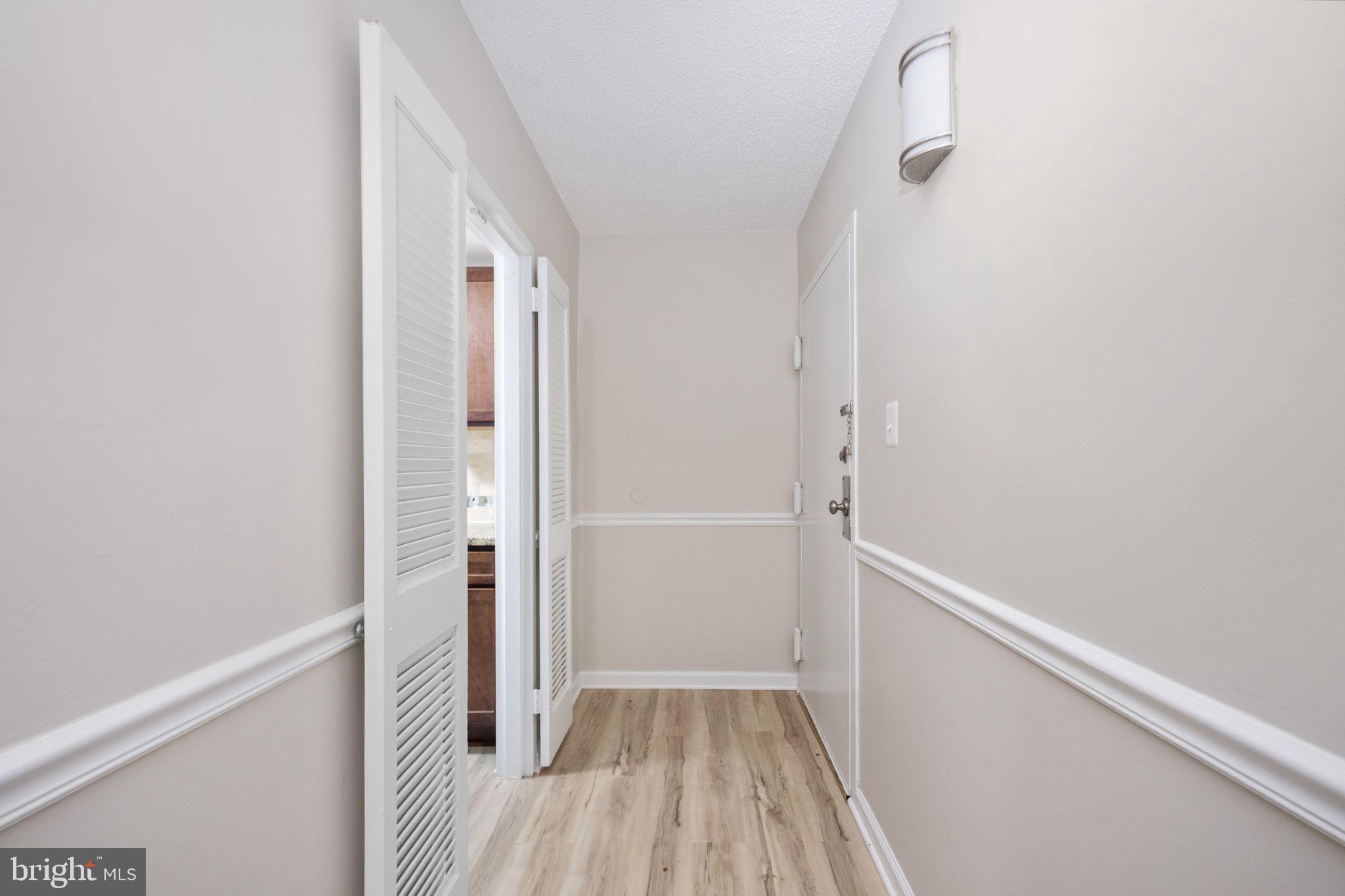 11659 Stoneview Square, Unit 11C Reston, VA 20191 - Photo 7 of 50 a view of a hallway with wooden floor and a bathroom