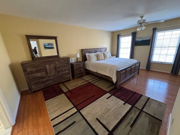 a bedroom with a bed rug and wooden floor