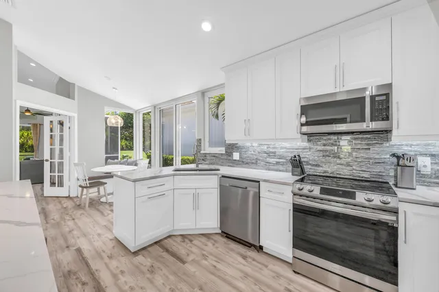 a kitchen with stainless steel appliances a stove sink microwave and cabinets