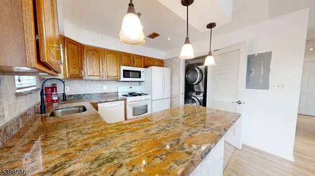 a kitchen with stainless steel appliances granite countertop a sink stove and refrigerator