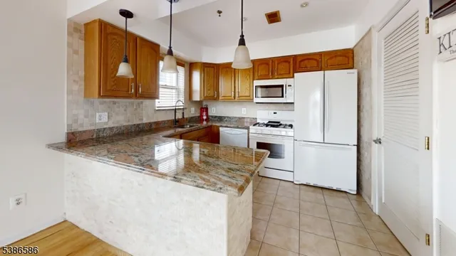 a kitchen with stainless steel appliances granite countertop a refrigerator a stove a sink and a refrigerator