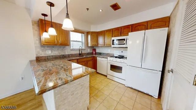 a kitchen with granite countertop a sink a counter top space and cabinets