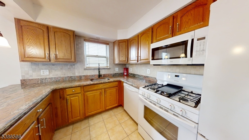 534 Maple Avenue Elizabeth, NJ 07202 - Photo 21 of 48 a kitchen with stainless steel appliances granite countertop a sink stove microwave and cabinets