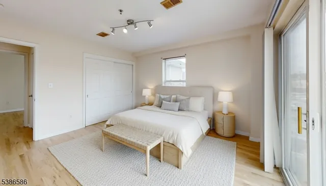 a view of a bedroom with wooden floor and windows