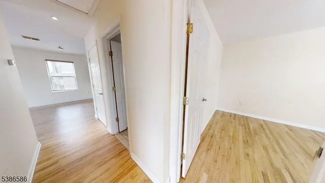 an empty room with wooden floor and a window