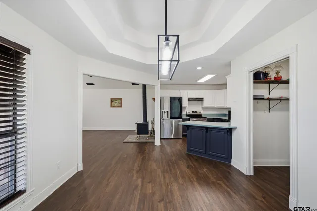 a kitchen with stainless steel appliances granite countertop a refrigerator a stove a sink and a wooden floors