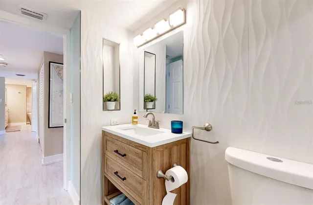 a bathroom with a sink a toilet and mirror