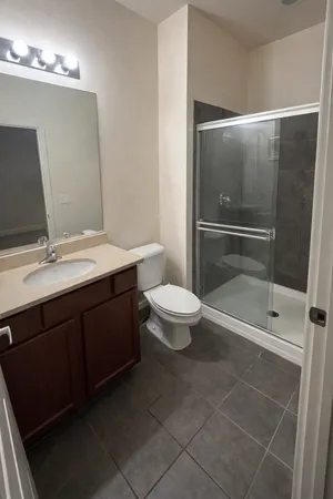a bathroom with a double vanity sink toilet and shower