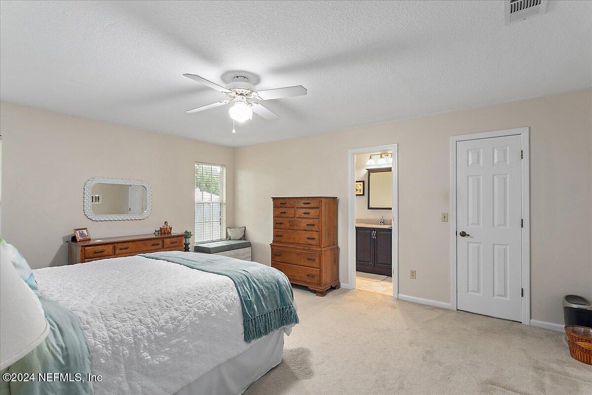 12417 Nesting Eagles Way Jacksonville, FL 32225 - Photo 11 of 23 a bedroom with a large bed a chandelier and dresser