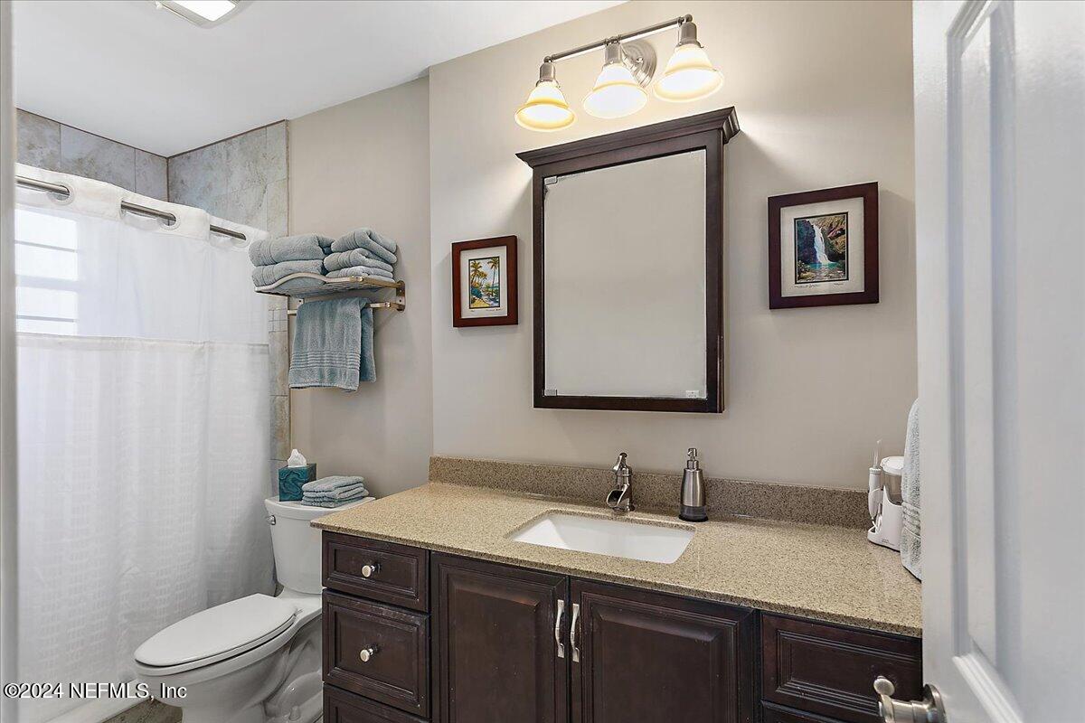 12417 Nesting Eagles Way Jacksonville, FL 32225 - Photo 12 of 23 a bathroom with a granite countertop sink toilet a mirror a vanity and shower