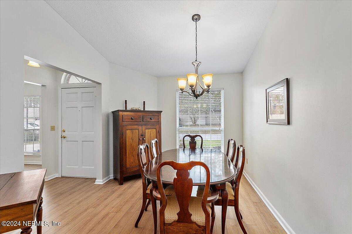 12417 Nesting Eagles Way Jacksonville, FL 32225 - Photo 4 of 23 a view of a dining room with furniture wooden floor and chandelier