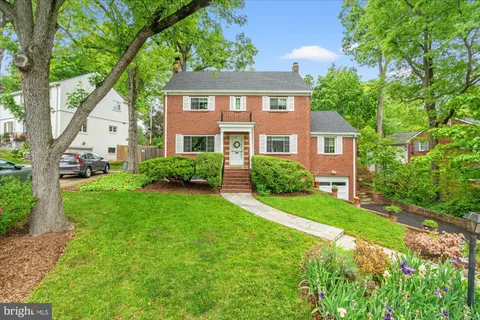 a front view of a house with a yard and trees