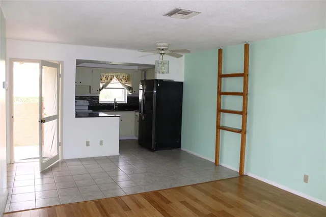 a view of a kitchen with wooden floor and a refrigerator