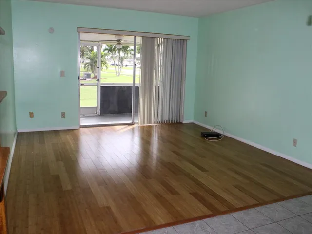 an empty room with wooden floor and a window