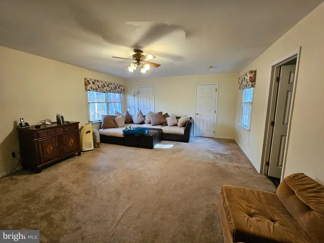 a living room with furniture a ceiling fan and a rug