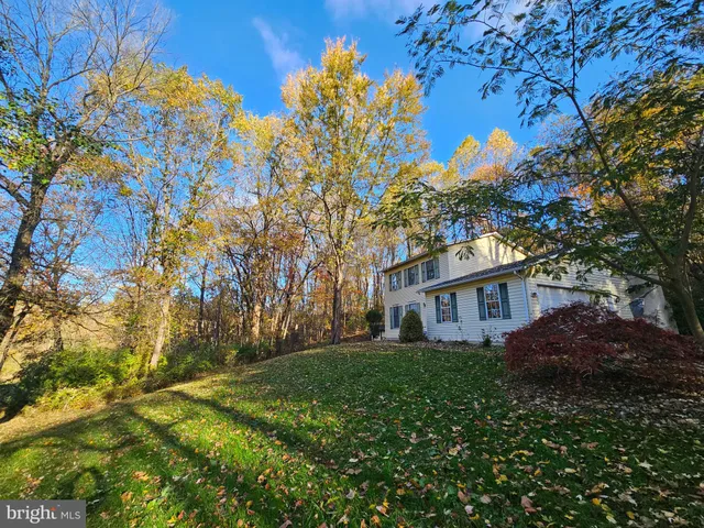 a view of house with yard and trees in the background
