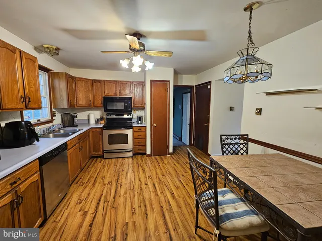a kitchen with granite countertop a stove refrigerator and microwave