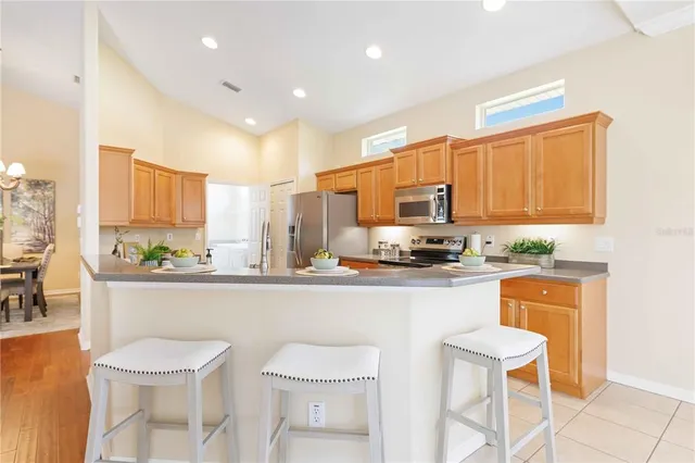 a large kitchen with kitchen island a large counter top space appliances and cabinets