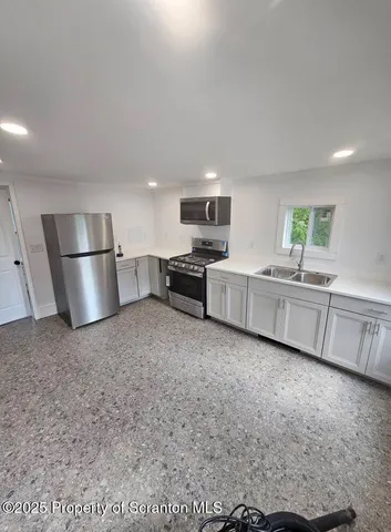 a kitchen with stainless steel appliances a refrigerator sink and white cabinets