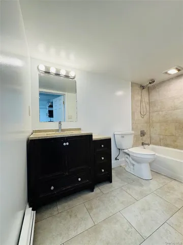 a spacious bathroom with a double vanity sink toilet mirror and bathtub