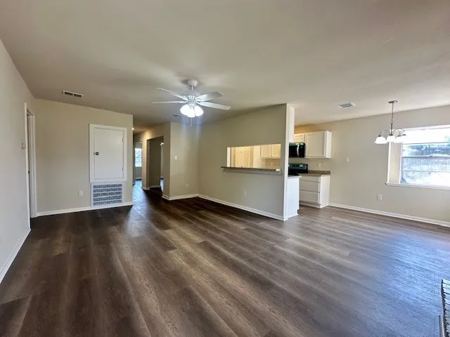 a view of a kitchen with wooden floor and a kitchen space