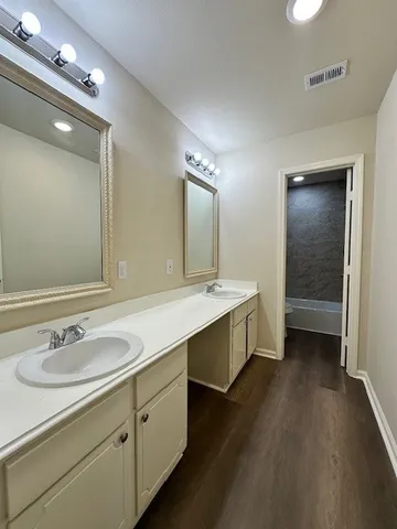 a bathroom with a double vanity sink a mirror and shower