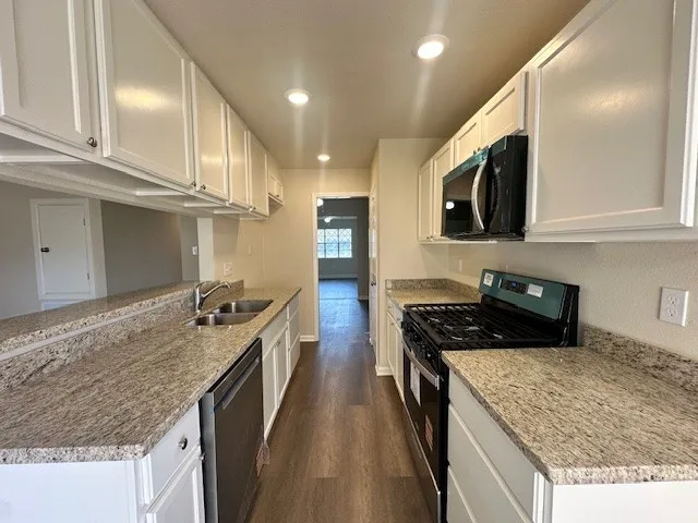 a kitchen with granite countertop kitchen island wooden cabinets and stainless steel appliances