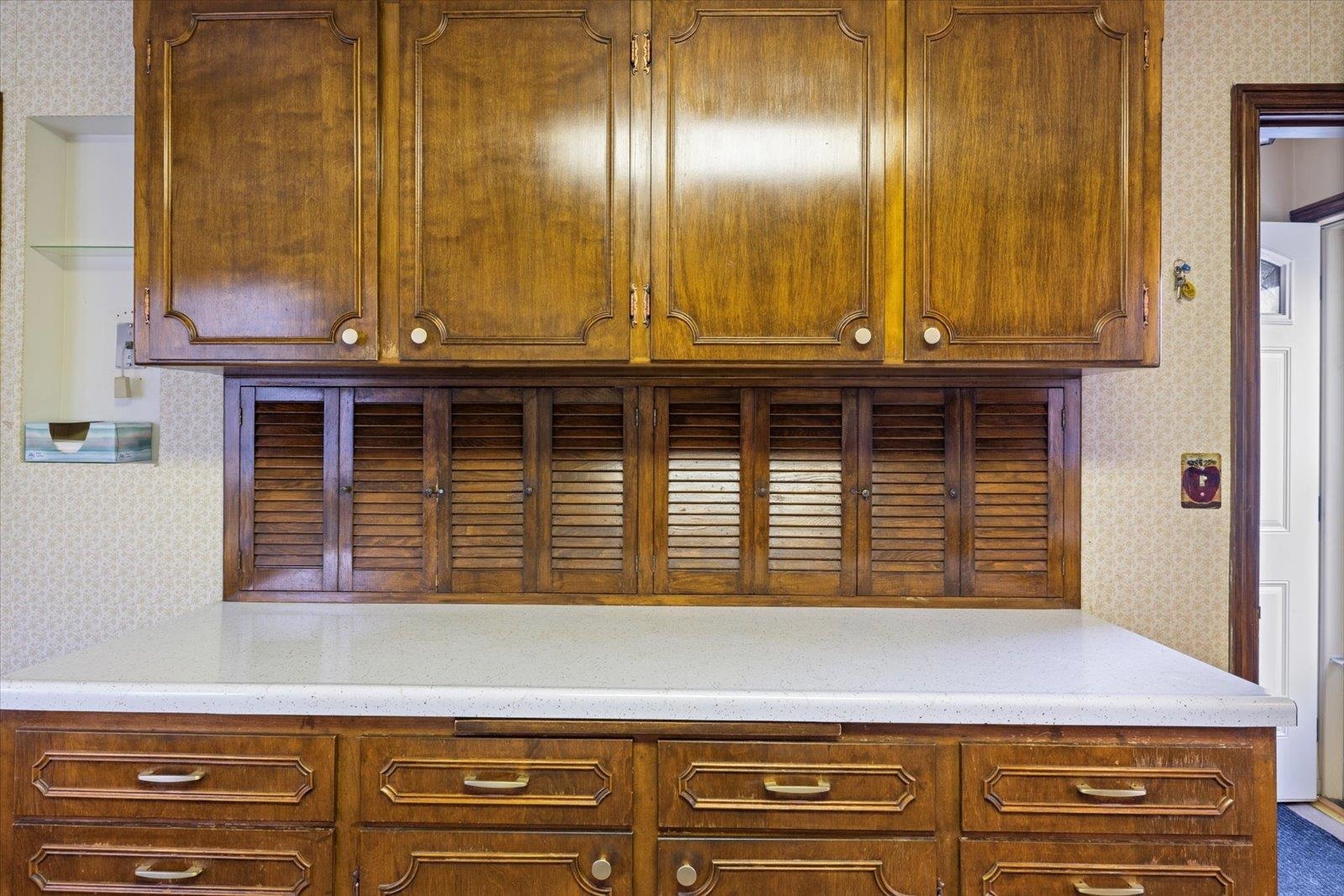 813 6th Street South Virginia, MN 55792 - Photo 20 of 44 Kitchen featuring wallpapered walls and brown cabinets