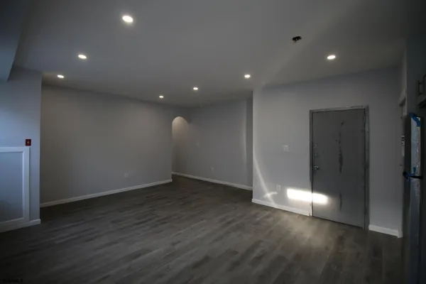 an empty room with wooden floor and entrance
