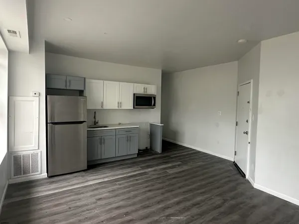 a kitchen with a refrigerator sink and cabinets