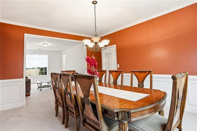 a view of a dining room with furniture and chandelier