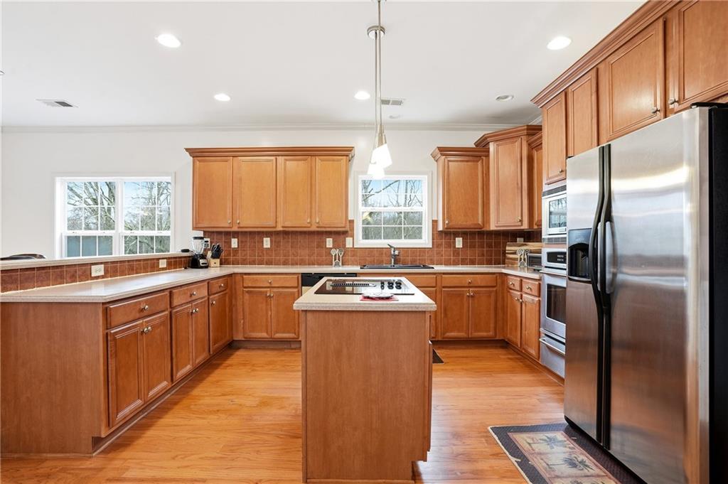 60 Heritage Keep Covington, GA 30016 - Photo 16 of 48 a kitchen with stainless steel appliances granite countertop a stove a sink dishwasher a refrigerator and white cabinets with wooden floor