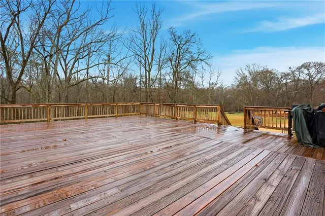 a view of a balcony with wooden floor and trees