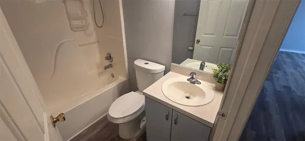 a white toilet sitting next to a sink and a mirror