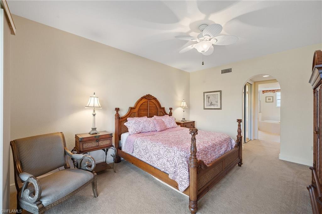 722 Regency Reserve Circle, Unit 3001 Naples, FL 34119 - Photo 11 of 22 a bedroom with a bed chairs and a chandelier
