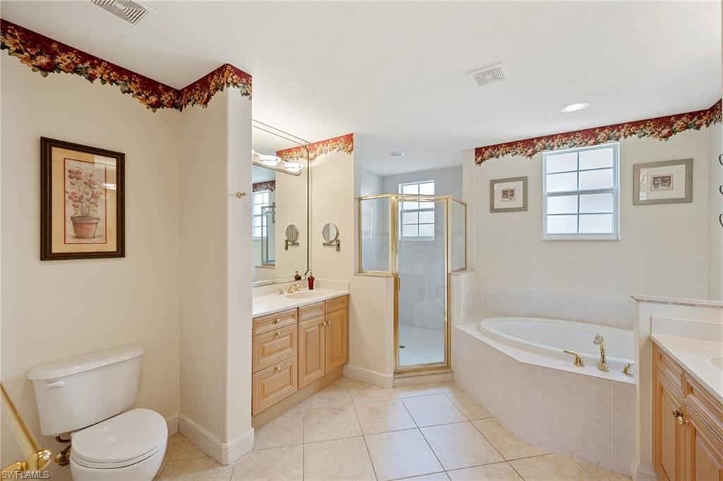 722 Regency Reserve Circle, Unit 3001 Naples, FL 34119 - Photo 12 of 22 a bathroom with a bathtub sink mirror vanity and toilet