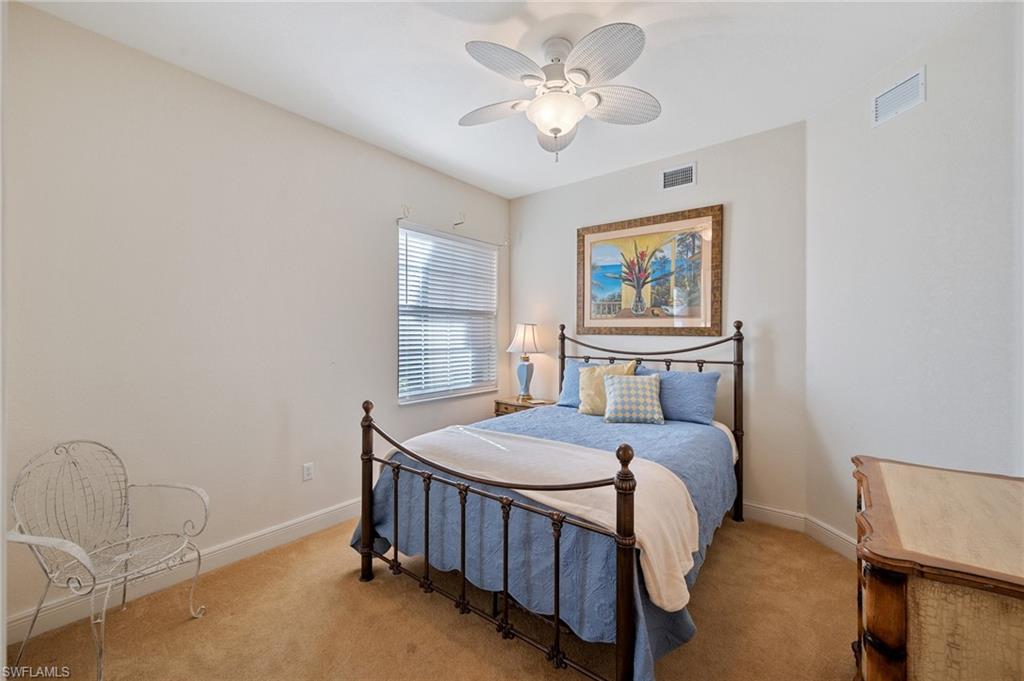 722 Regency Reserve Circle, Unit 3001 Naples, FL 34119 - Photo 13 of 22 a bedroom with a bed and a chandelier