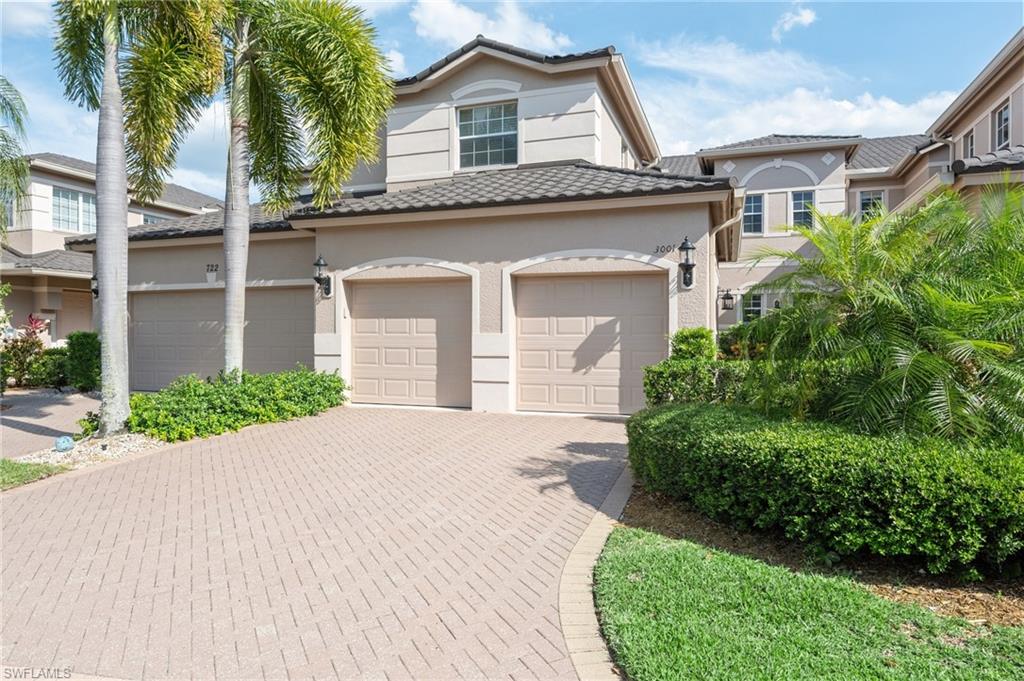 722 Regency Reserve Circle, Unit 3001 Naples, FL 34119 - Photo 2 of 22 a front view of a house with a garden and palm trees