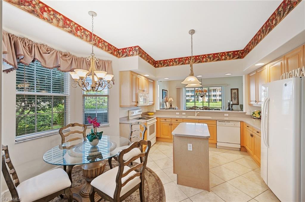 722 Regency Reserve Circle, Unit 3001 Naples, FL 34119 - Photo 6 of 22 a dining table chairs and a kitchen view